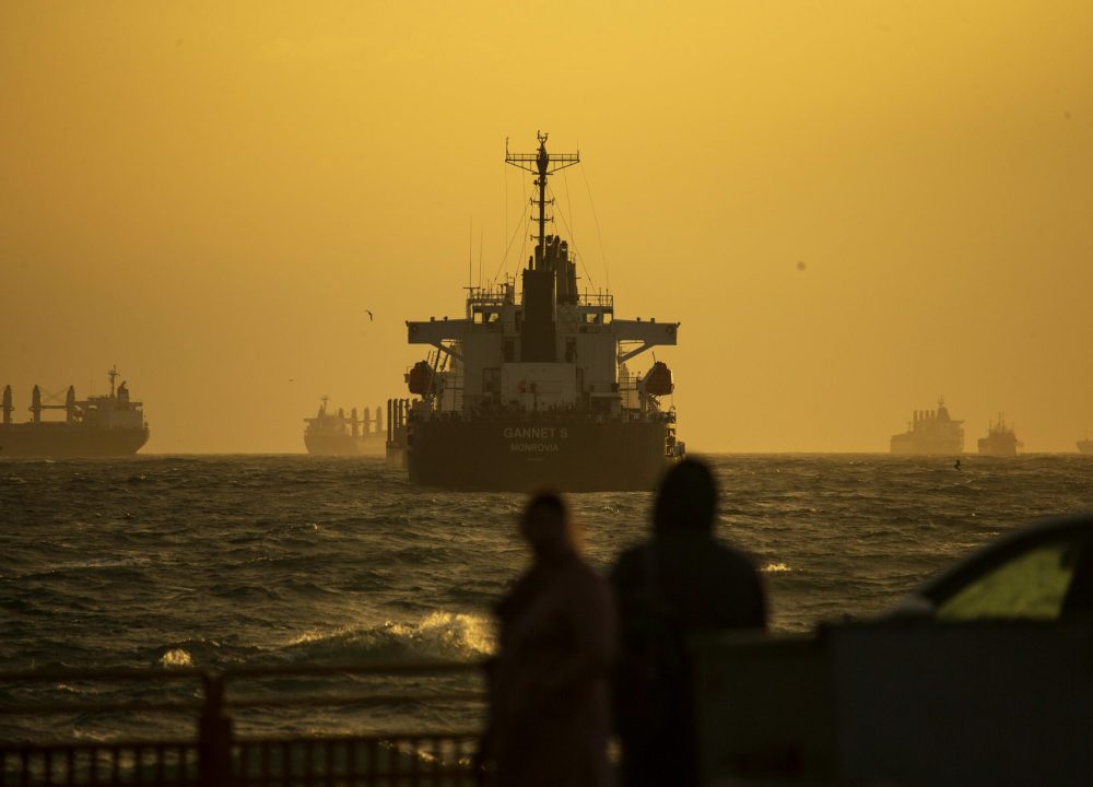 Silhouetted ships navigate the Bosporus Strait at sunset, creating a dramatic scene in Istanbul.