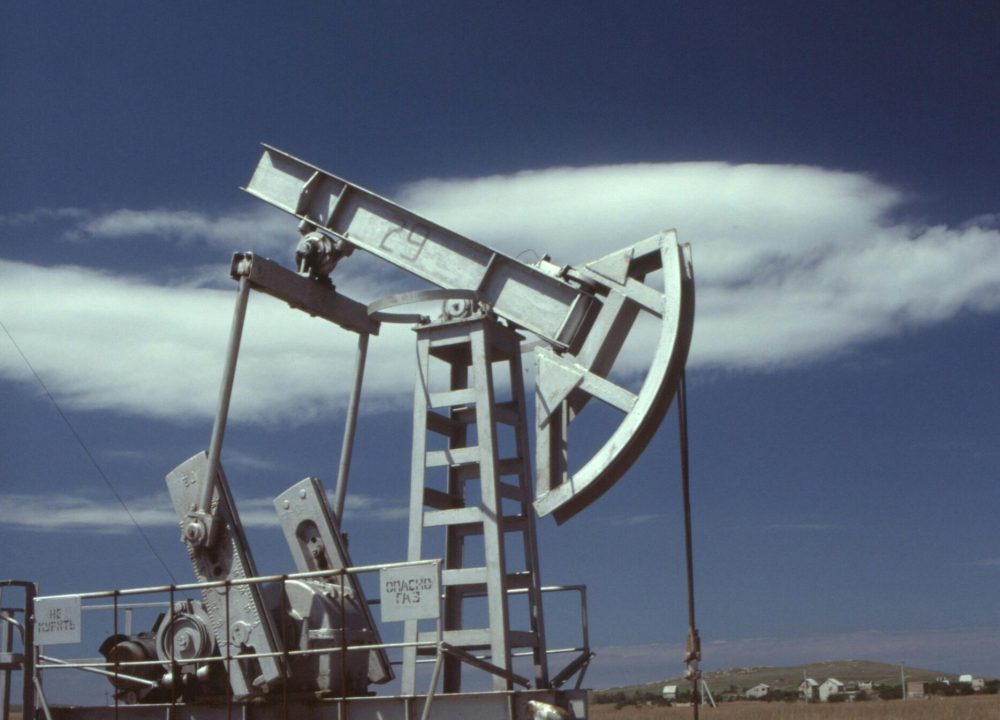 Oil pumpjack in operation against clear blue sky, highlighting industrial energy production.